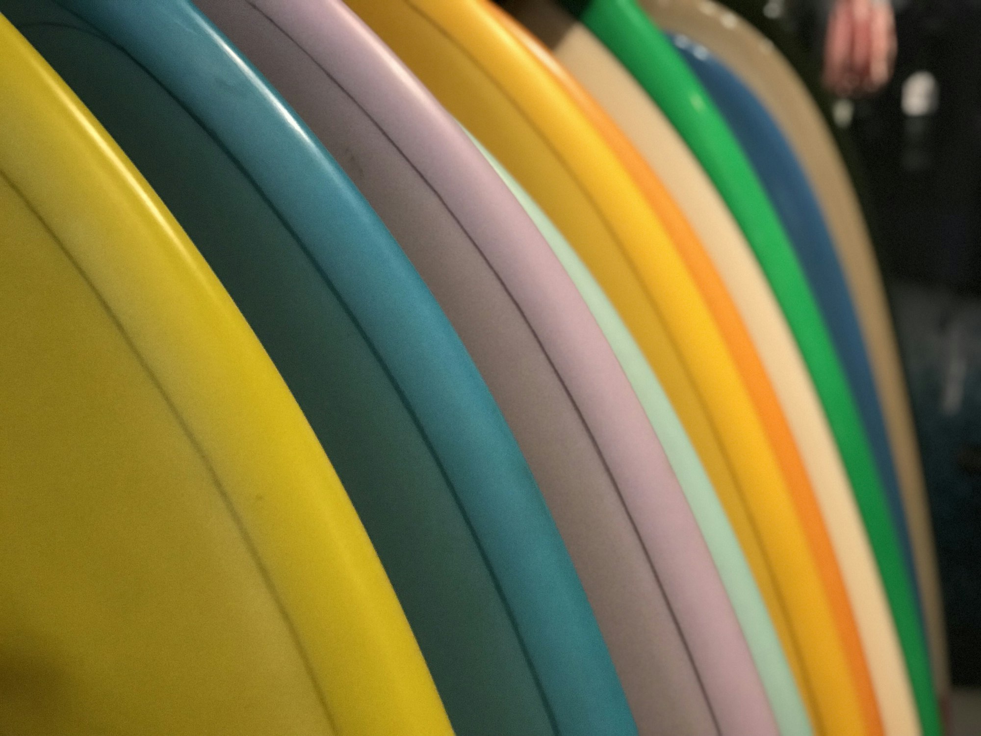 A row of colorful surfboards in a retail shop